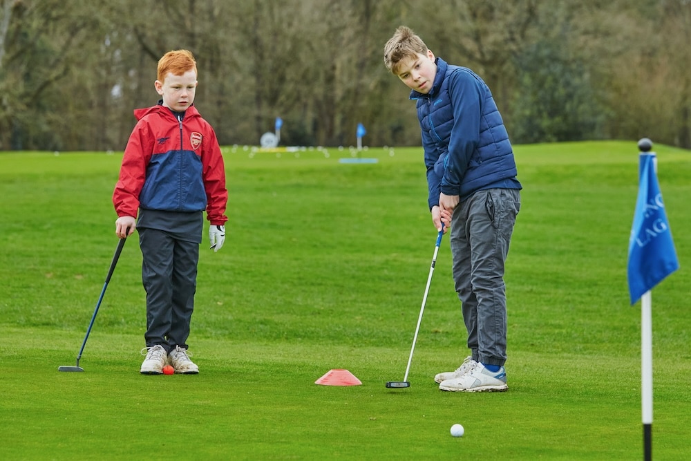 Two young boys putting