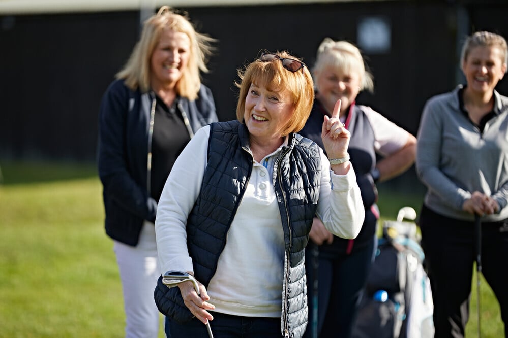 women happy playing golf